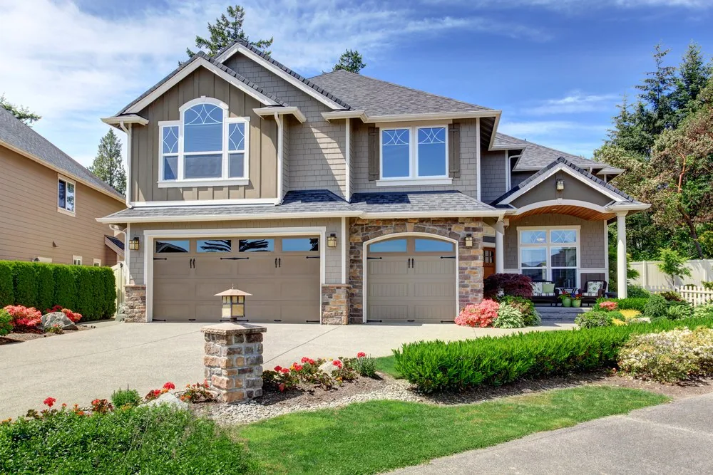 Two carriage-style garage doors with arched windows on a craftsman home